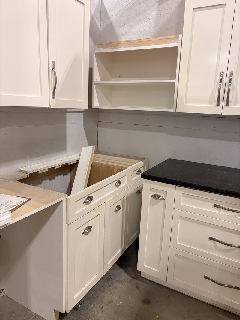 White Kitchen with Glass Accented Doors, Black Granite, and a Statement Wall Unit