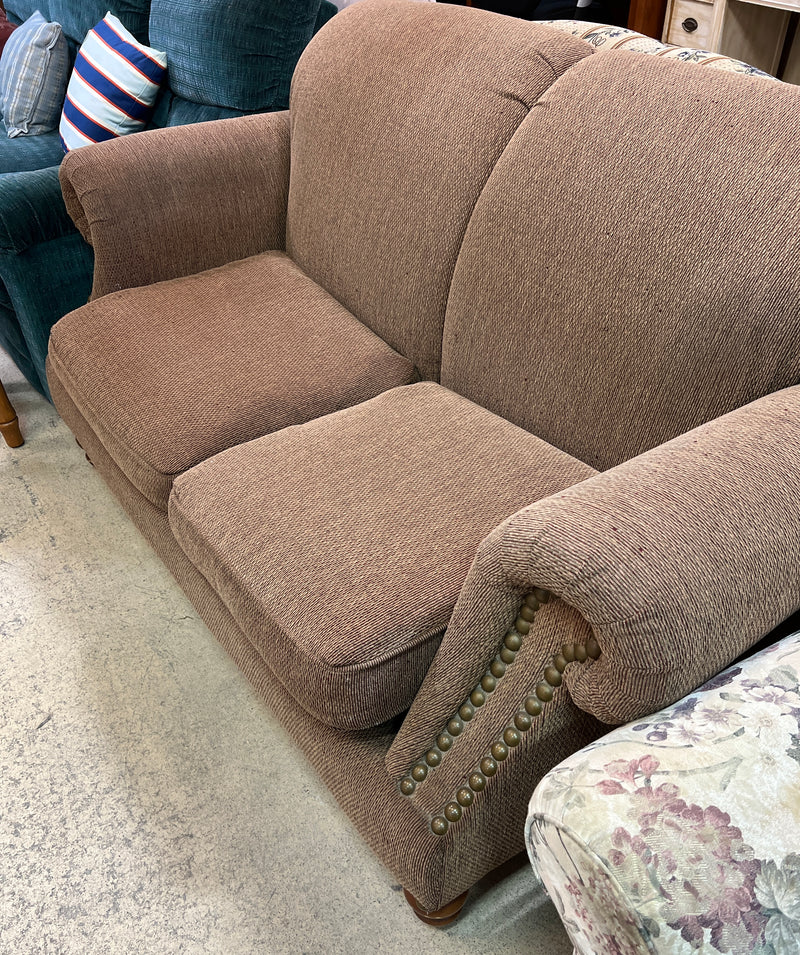 Tan Textured Fabric Loveseat with Rolled Arms and Nailhead Trim