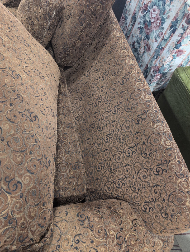 Brown 2 Seater Sofa with Swirly Patterns and Pillows